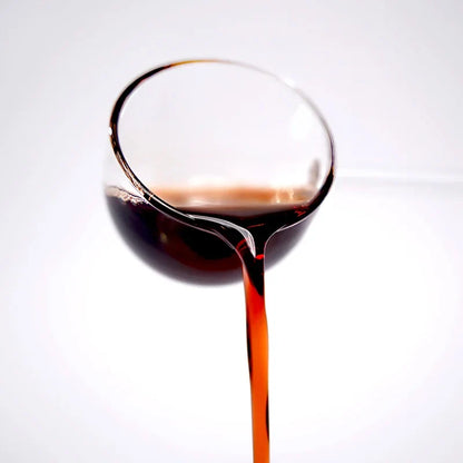Close-up of blueberry concentrated syrup pouring, featuring a deep purple-red color and rich berry texture.