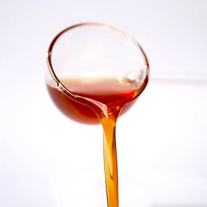 Close-up of kumquat lemon concentrated syrup pouring, showcasing a zesty amber glow and a perfect sweet-tart citrus balance.