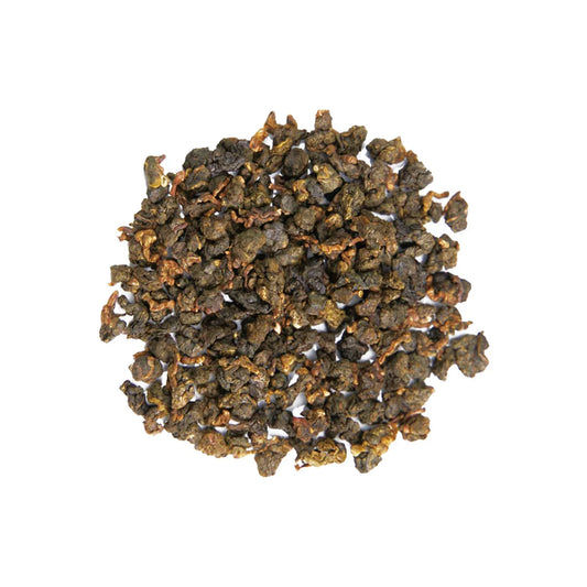 Close-up of Milky Mist Jin Xuan loose leaf tea, tightly rolled oolong tea leaves with a natural green and golden tint.